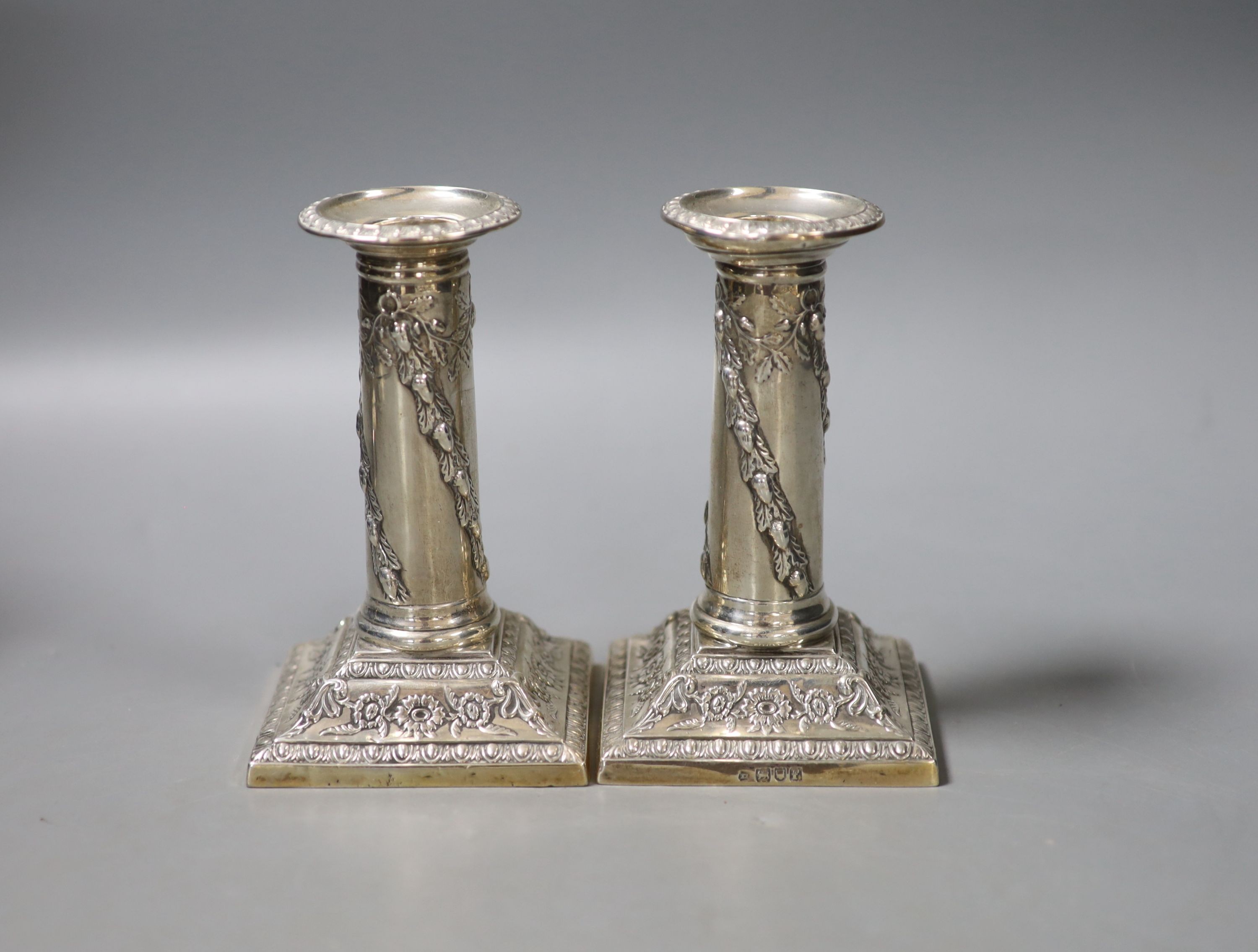 A pair of early 20th century repousse silver dwarf candlesticks, Thomas Bradbury & Sons, Sheffield, 190 & London, 1901, 12.6cm, weighted.